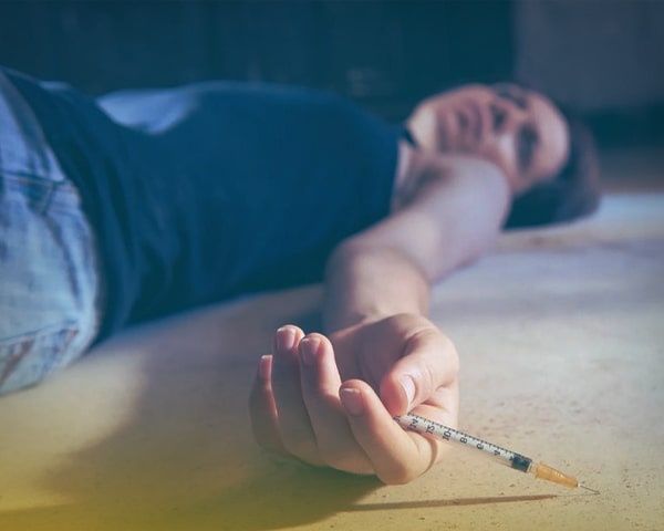 Девушка лежит со шприцом в руке